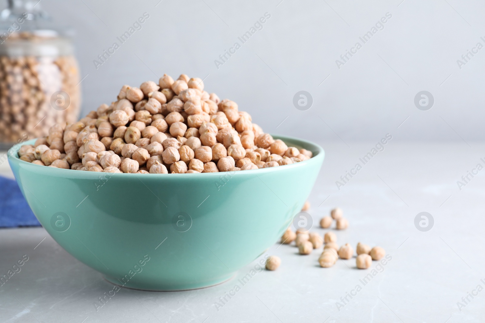 Photo of Chickpeas in bowl on light table, space for text