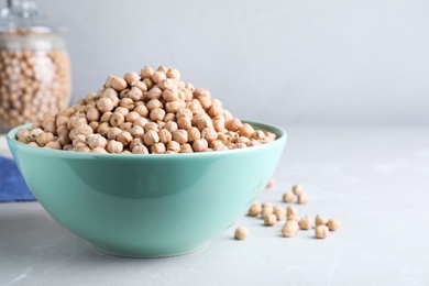 Photo of Chickpeas in bowl on light table, space for text