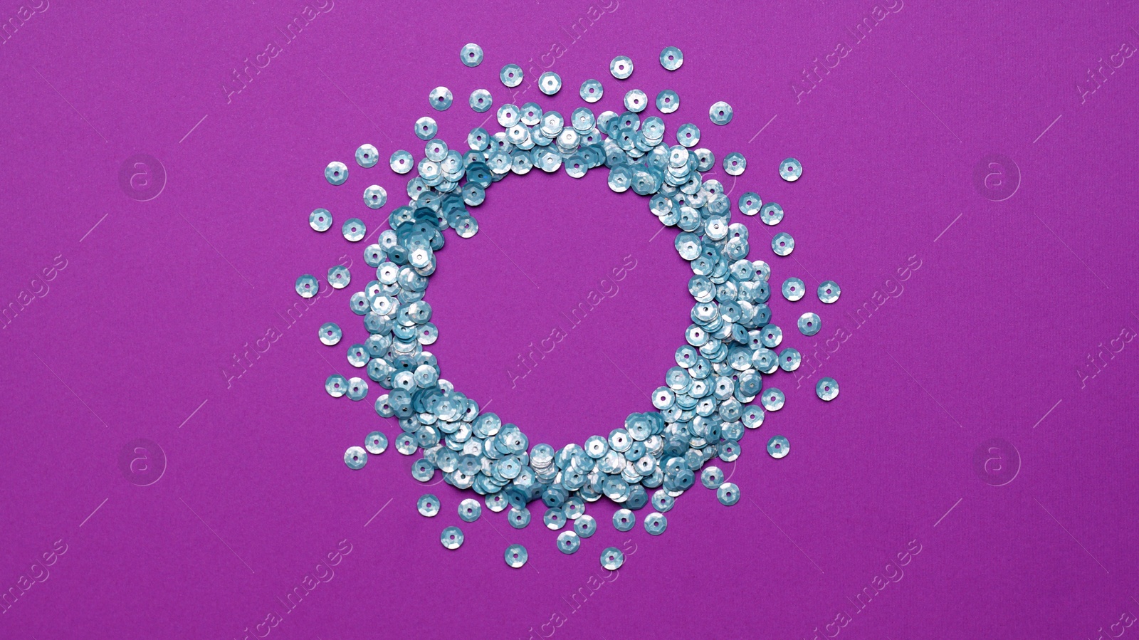 Photo of Circle made of silver sequins on purple background, top view