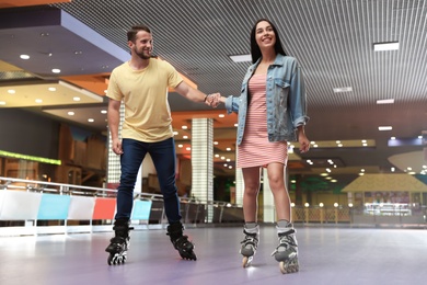 Young couple spending time at roller skating rink