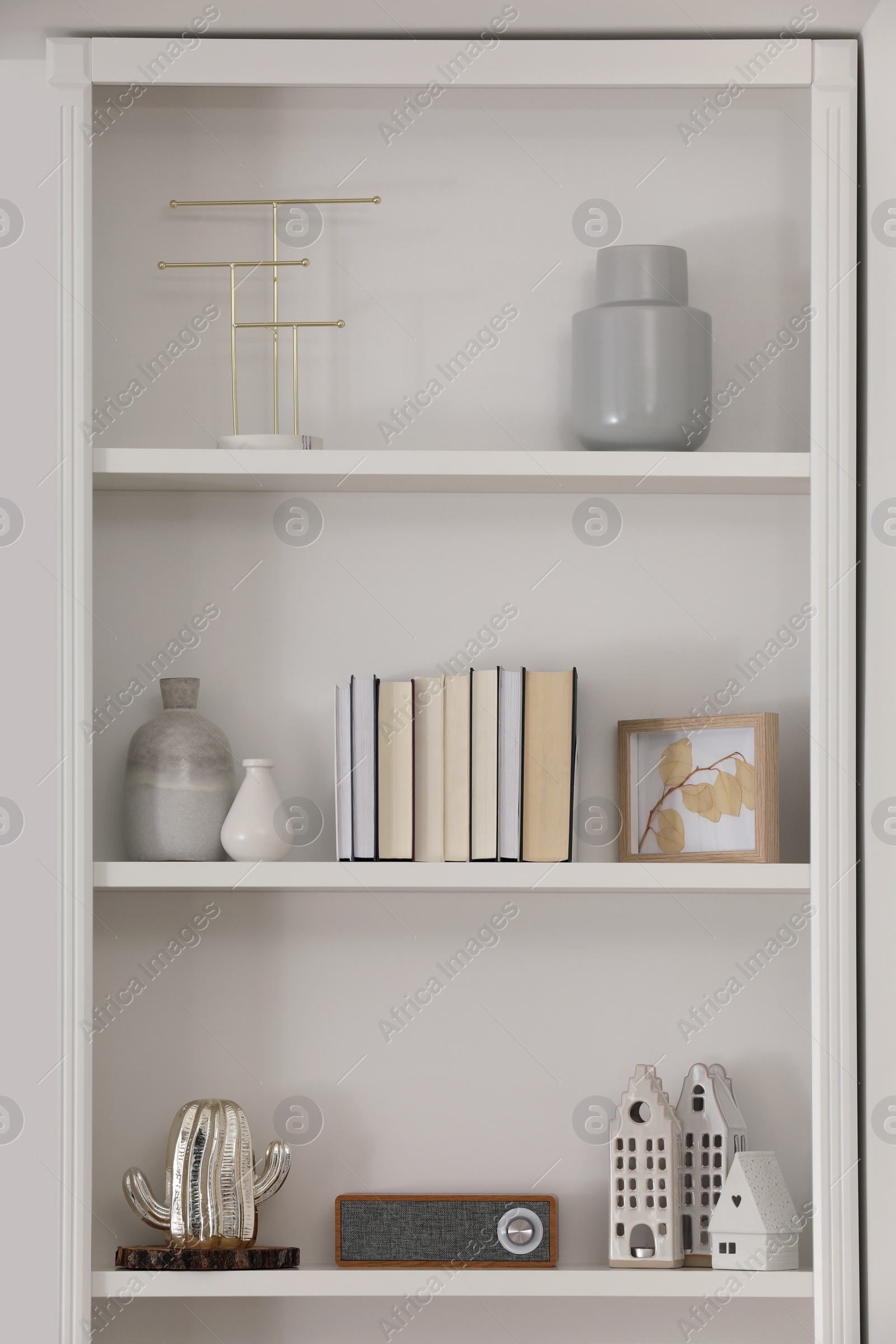 Photo of Stylish shelves with different decor elements in room. Interior design