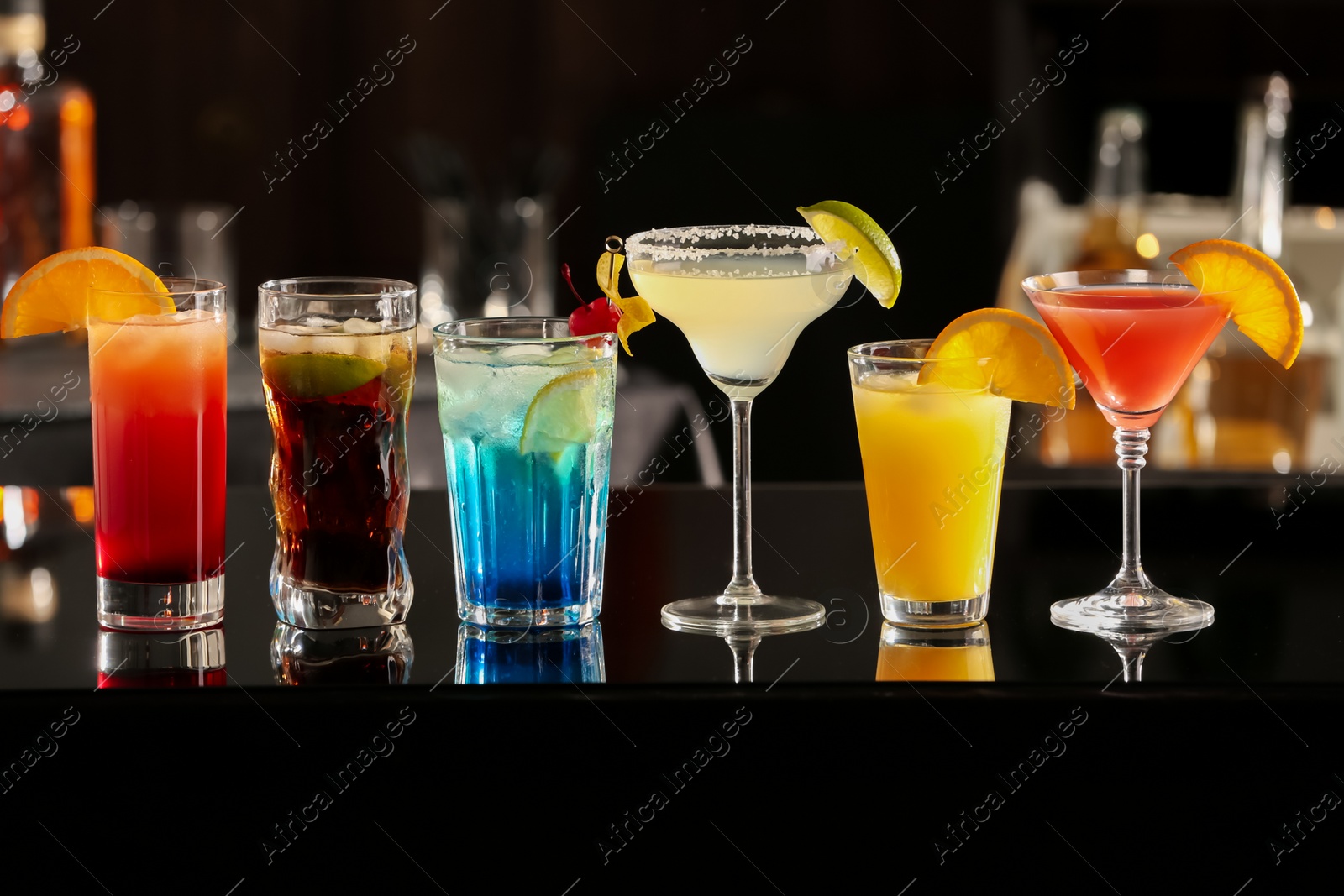 Photo of Different delicious cocktails on counter in bar