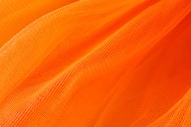 Photo of Texture of orange tulle as background, closeup