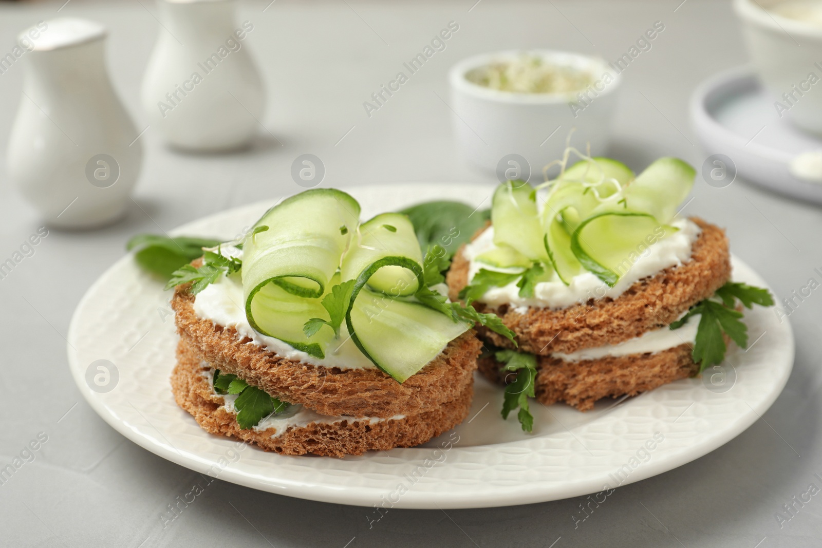 Photo of Plate with traditional English cucumber sandwiches on table