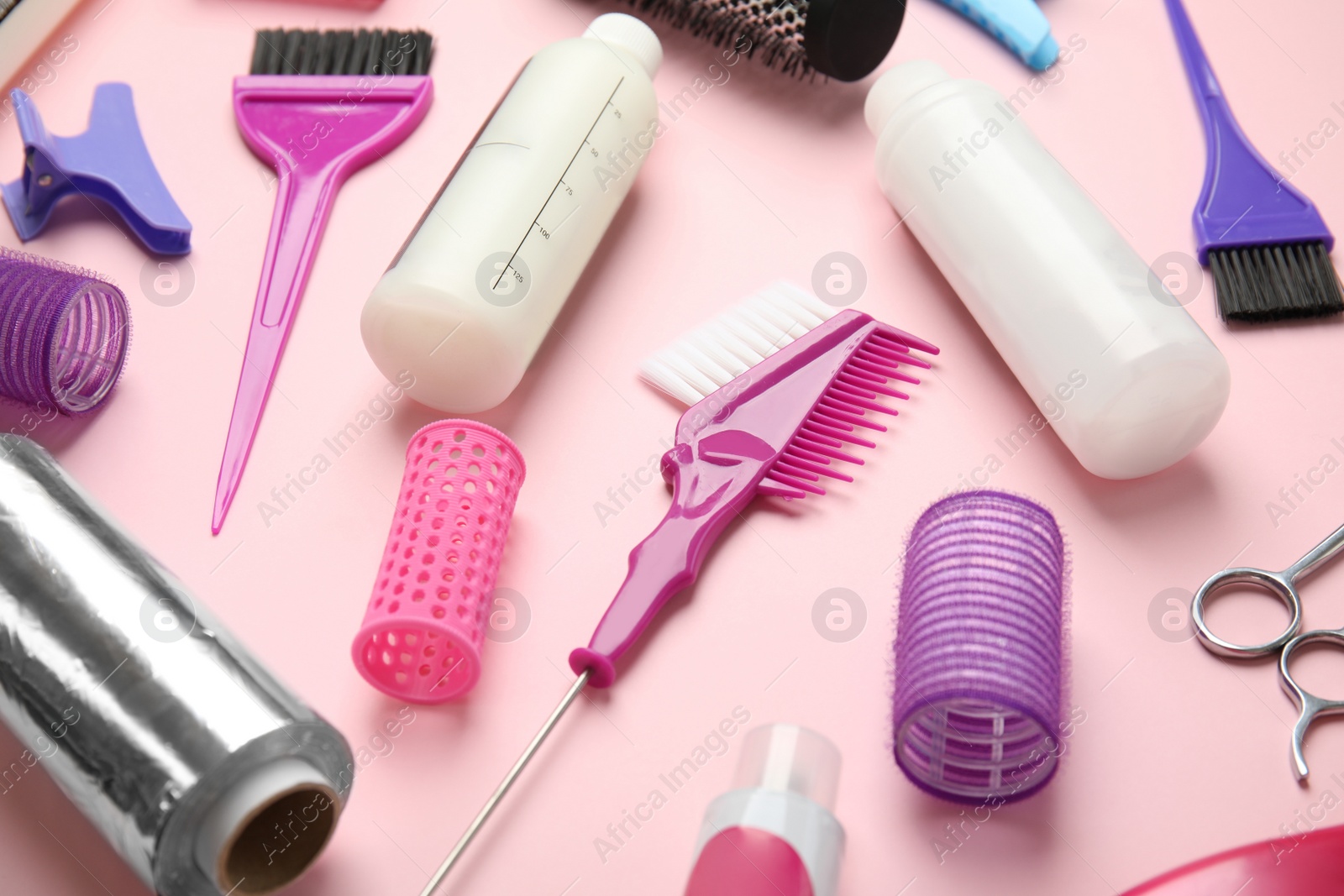 Photo of Professional tools for hair dyeing on pink background