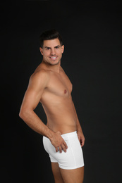 Photo of Handsome man in underwear on black background