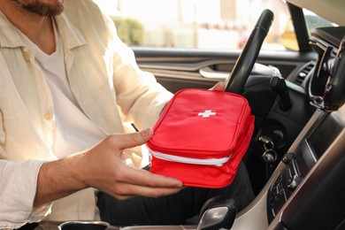 Photo of Man with first aid kit inside car, closeup