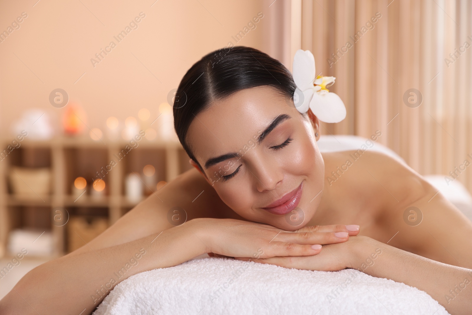 Photo of Young woman resting on massage couch in spa salon