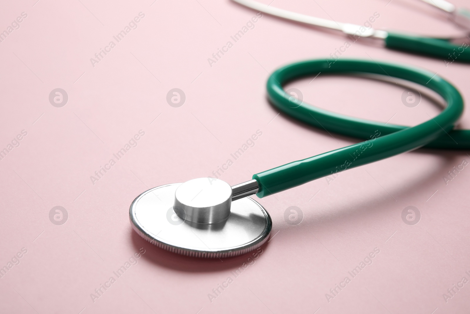 Photo of Stethoscope with space for text on color background, closeup. Medical tool