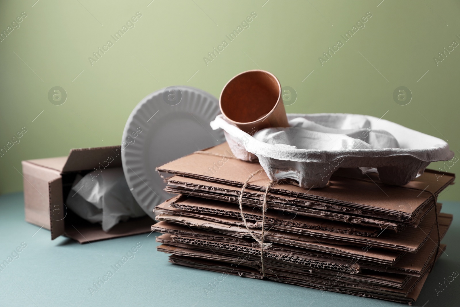 Photo of Different waste paper on grey table near light green wall