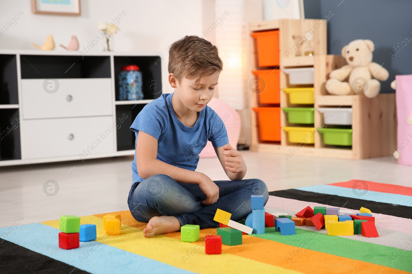 Photo of Little autistic boy playing with cubes at home