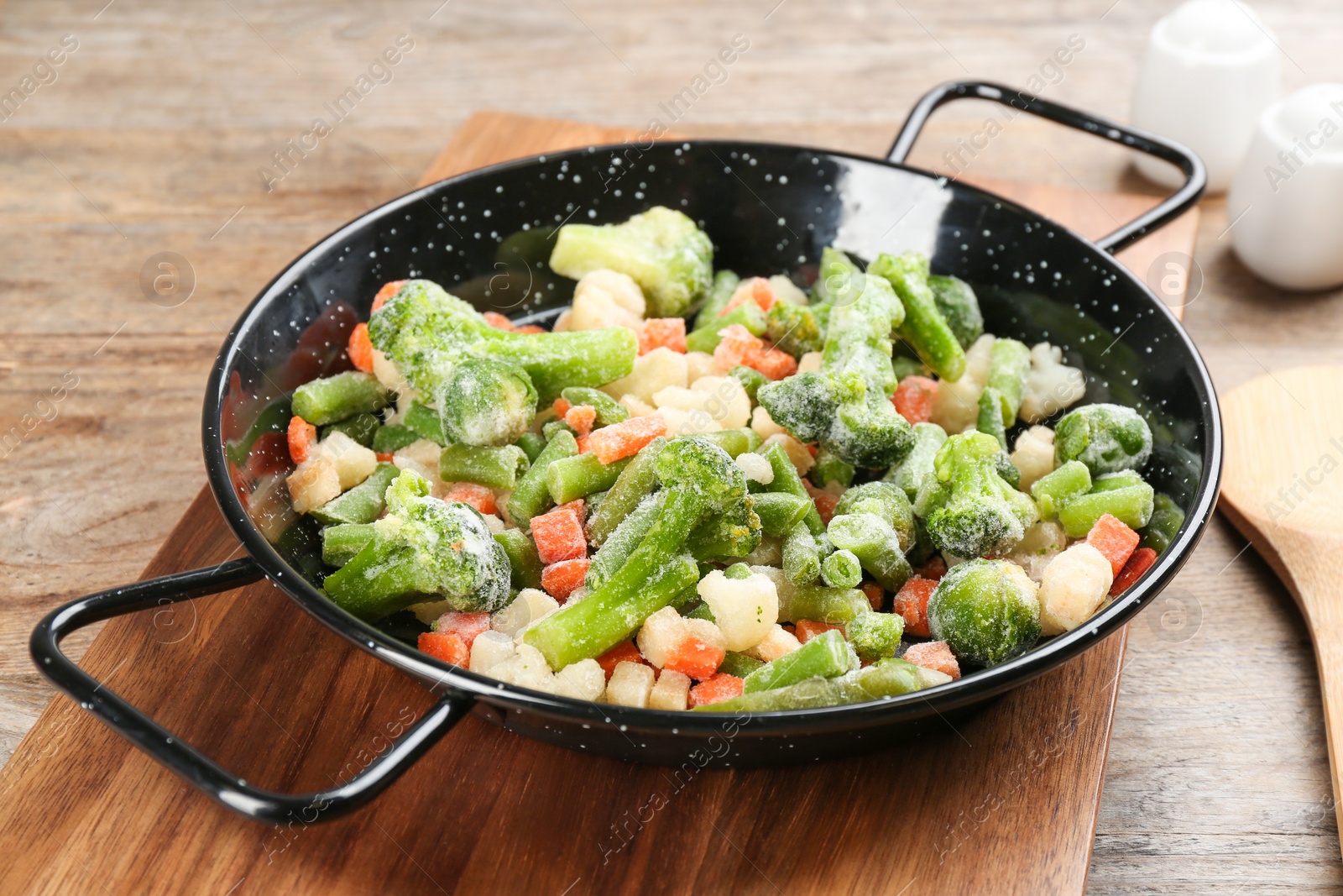 Photo of Tasty frozen vegetable mix on wooden table, closeup