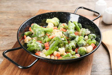 Photo of Tasty frozen vegetable mix on wooden table, closeup