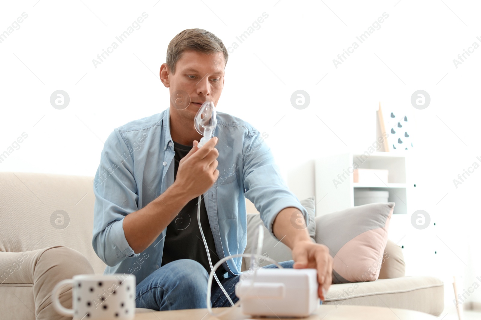 Photo of Man using asthma machine at home. Health care