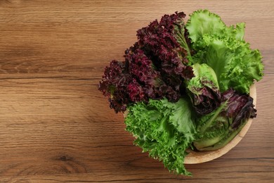 Different sorts of lettuce on wooden table, top view. Space for text