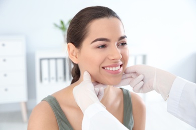 Photo of Dermatologist examining patient's face in clinic. Skin cancer checkup