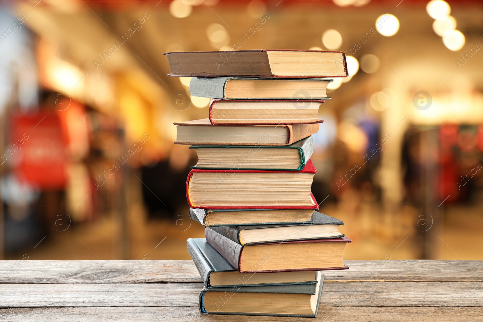 Image of Collection of different books on wooden table against blurred background