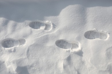 Photo of Bootprints on snow outdoors, top view. Winter season