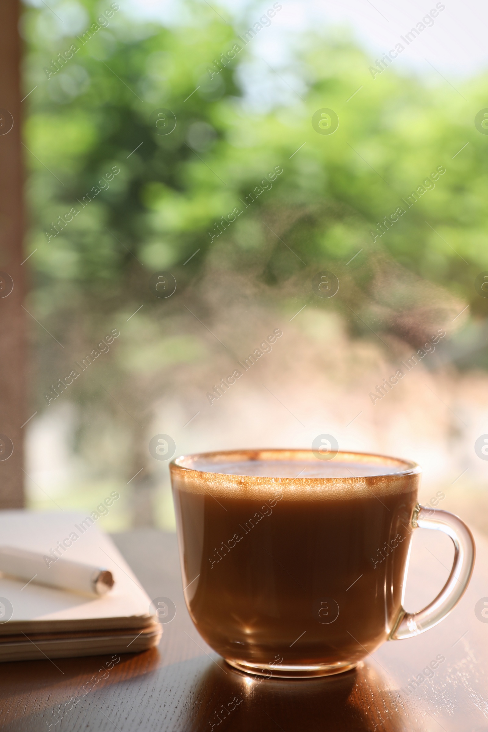 Photo of Cup of delicious morning coffee on wooden table