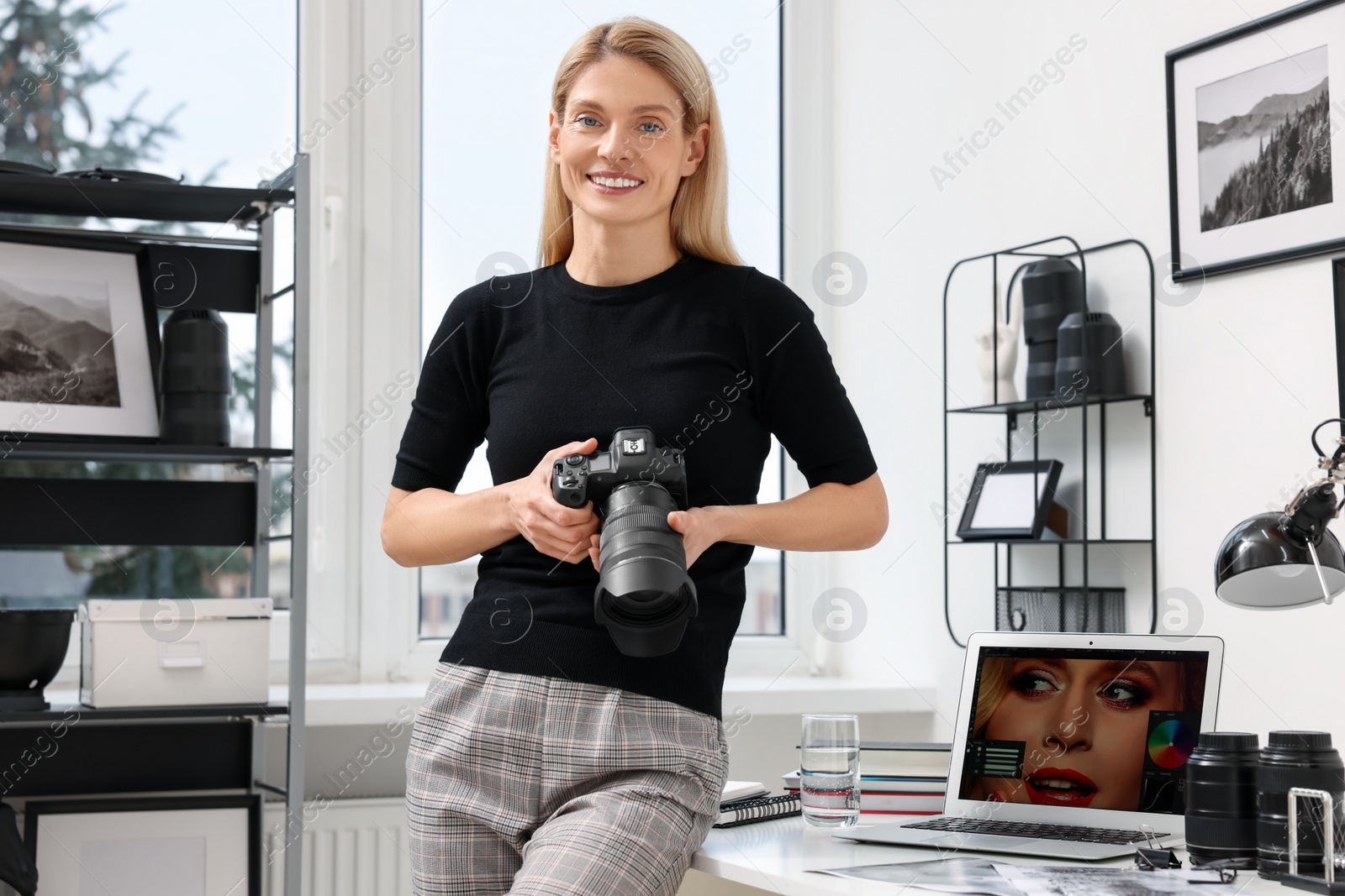 Photo of Professional photographer with modern digital camera in office