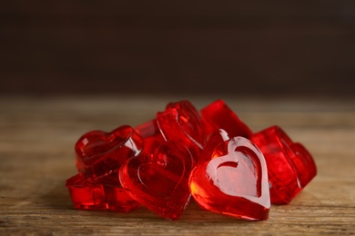 Sweet heart shaped jelly candies on wooden table, closeup