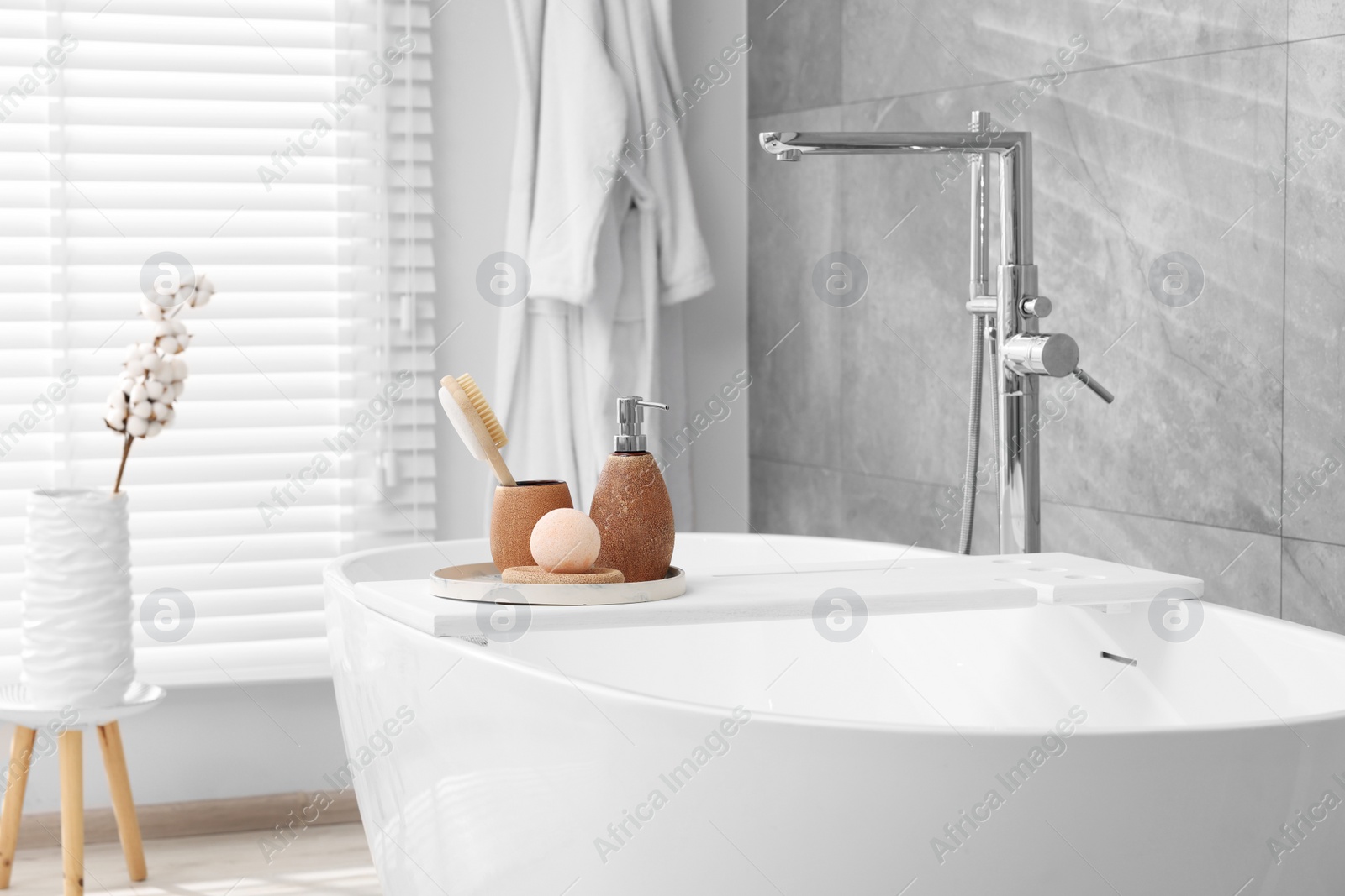 Photo of Different personal care products and accessories on bath tub in bathroom