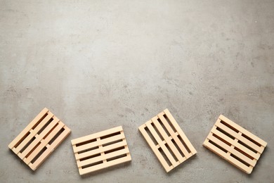 Photo of Wooden pallets on light grey table, flat lay. Space for text