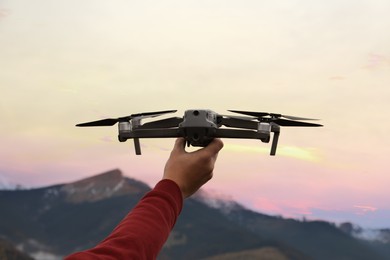 Photo of Man with modern drone in mountains, closeup