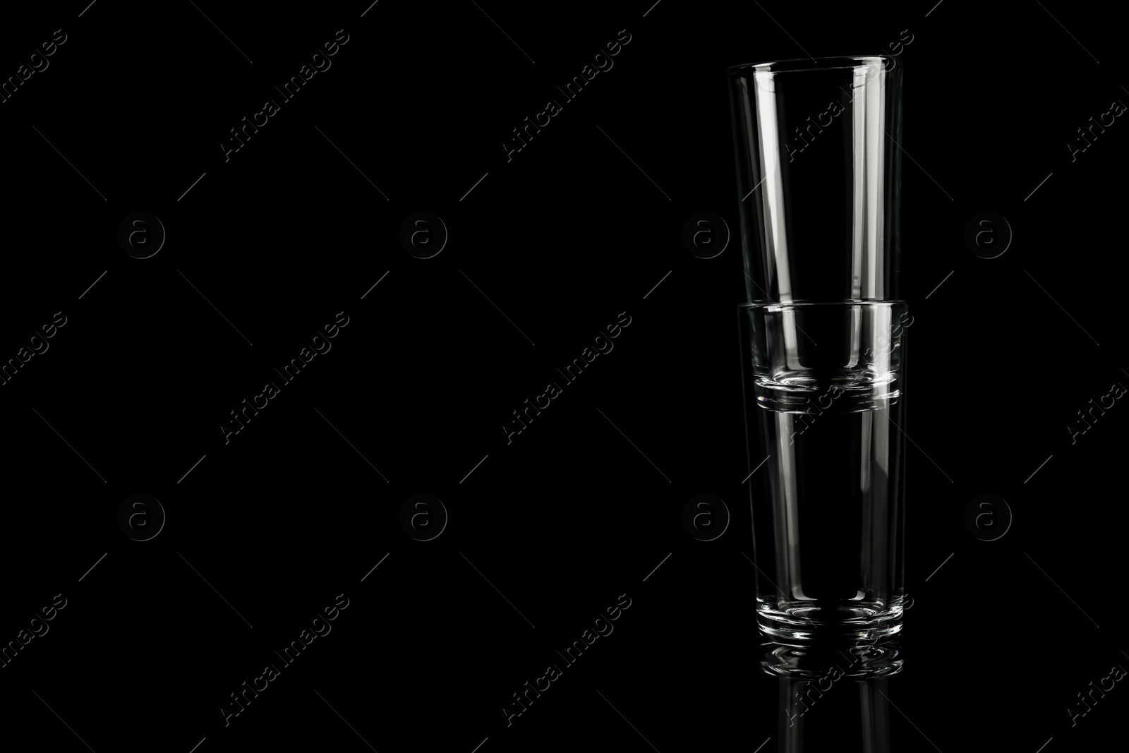 Photo of Empty glasses on black background. Space for text