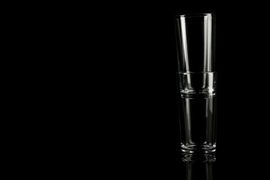 Photo of Empty glasses on black background. Space for text