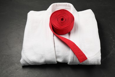 Photo of Red karate belt and white kimono on gray background