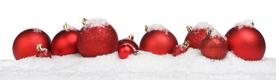 Photo of Beautiful red Christmas balls on snow against white background