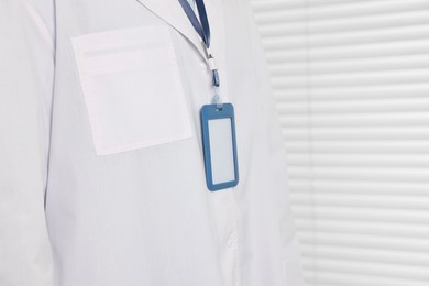 Photo of Doctor with empty badge in hospital, closeup. Space for text