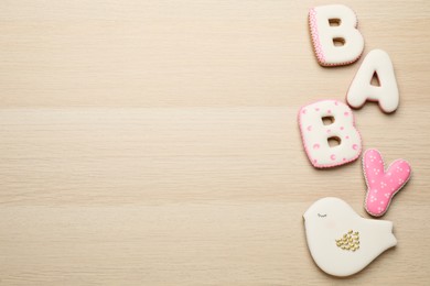Photo of Word Baby made of tasty cookies on white wooden table, flat lay. Space for text