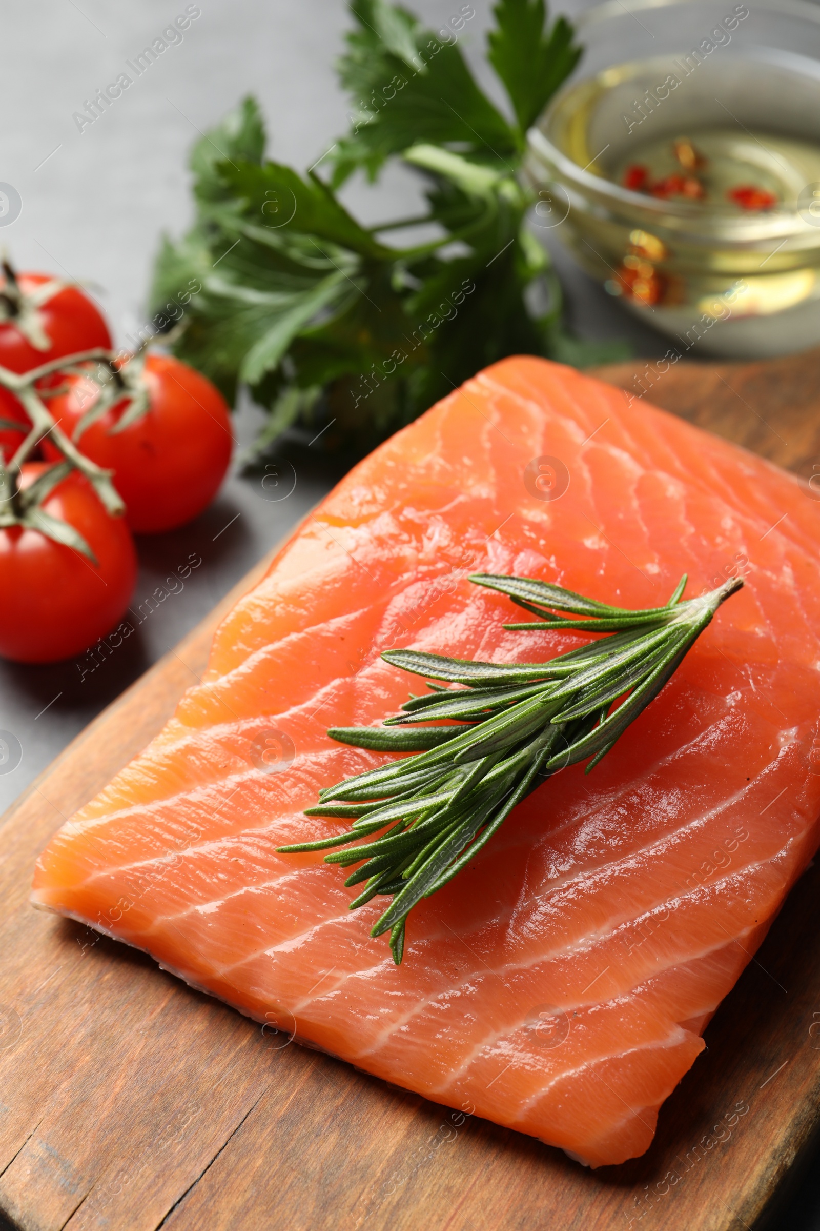 Photo of Fresh raw salmon and ingredients for marinade on wooden board, closeup