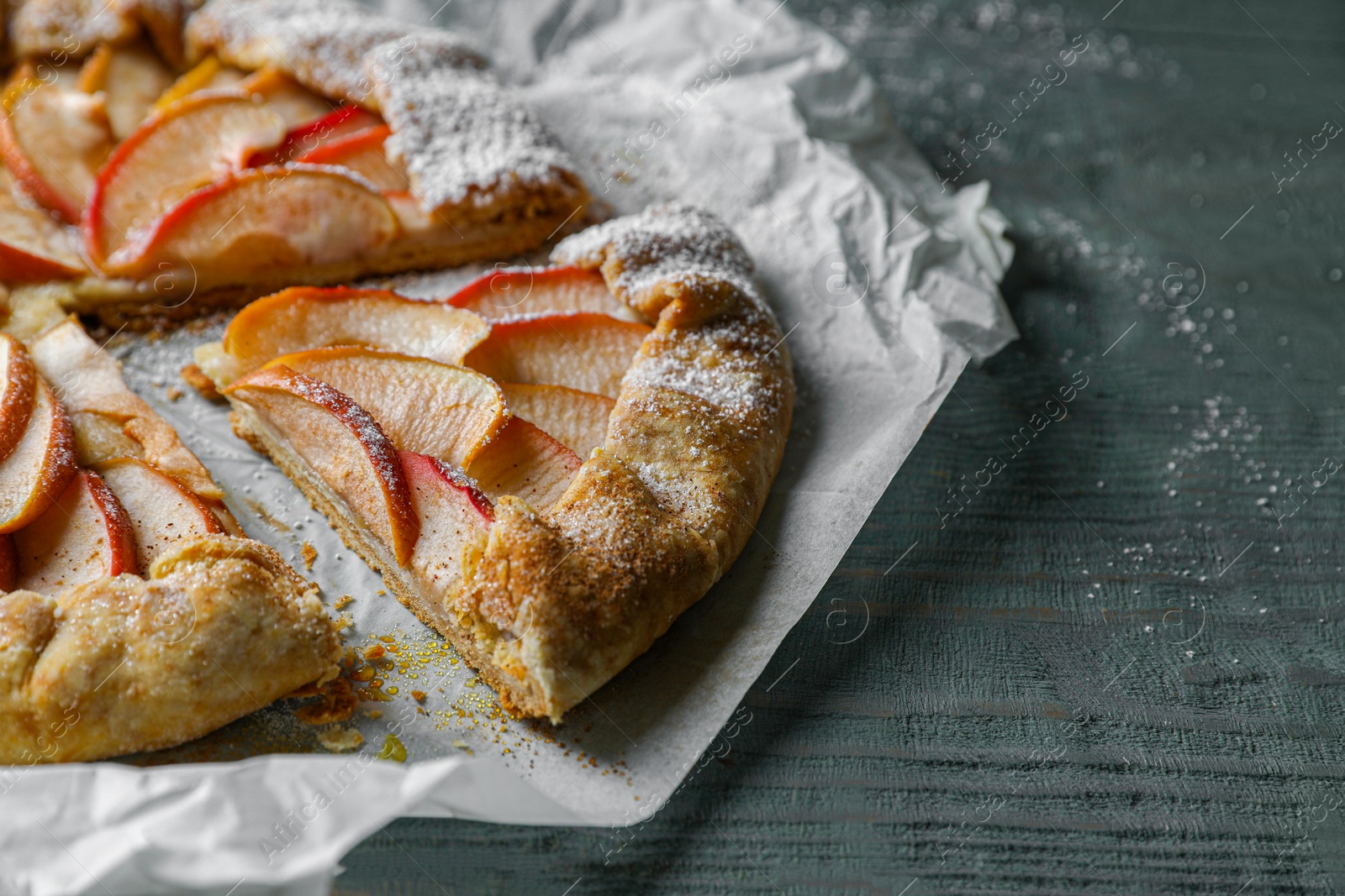 Photo of Delicious apple galette on wooden table, closeup. Space for text