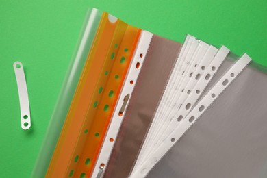 Photo of File folder with punched pockets on green background, flat lay