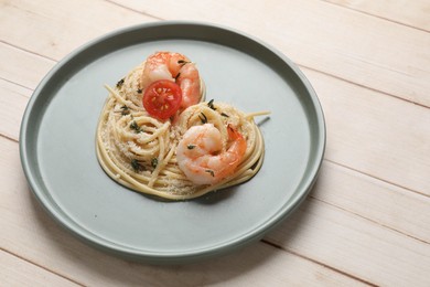 Photo of Heart made of tasty spaghetti, tomato, shrimps and cheese on light wooden table