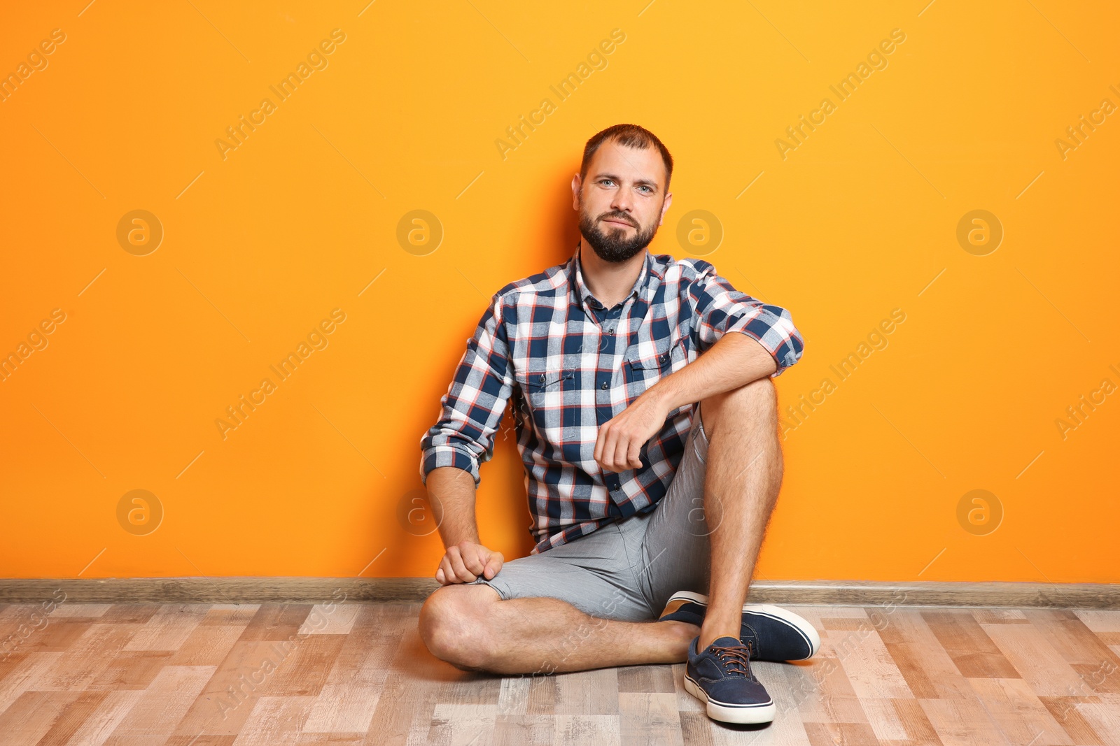 Photo of Man in casual clothes near color wall