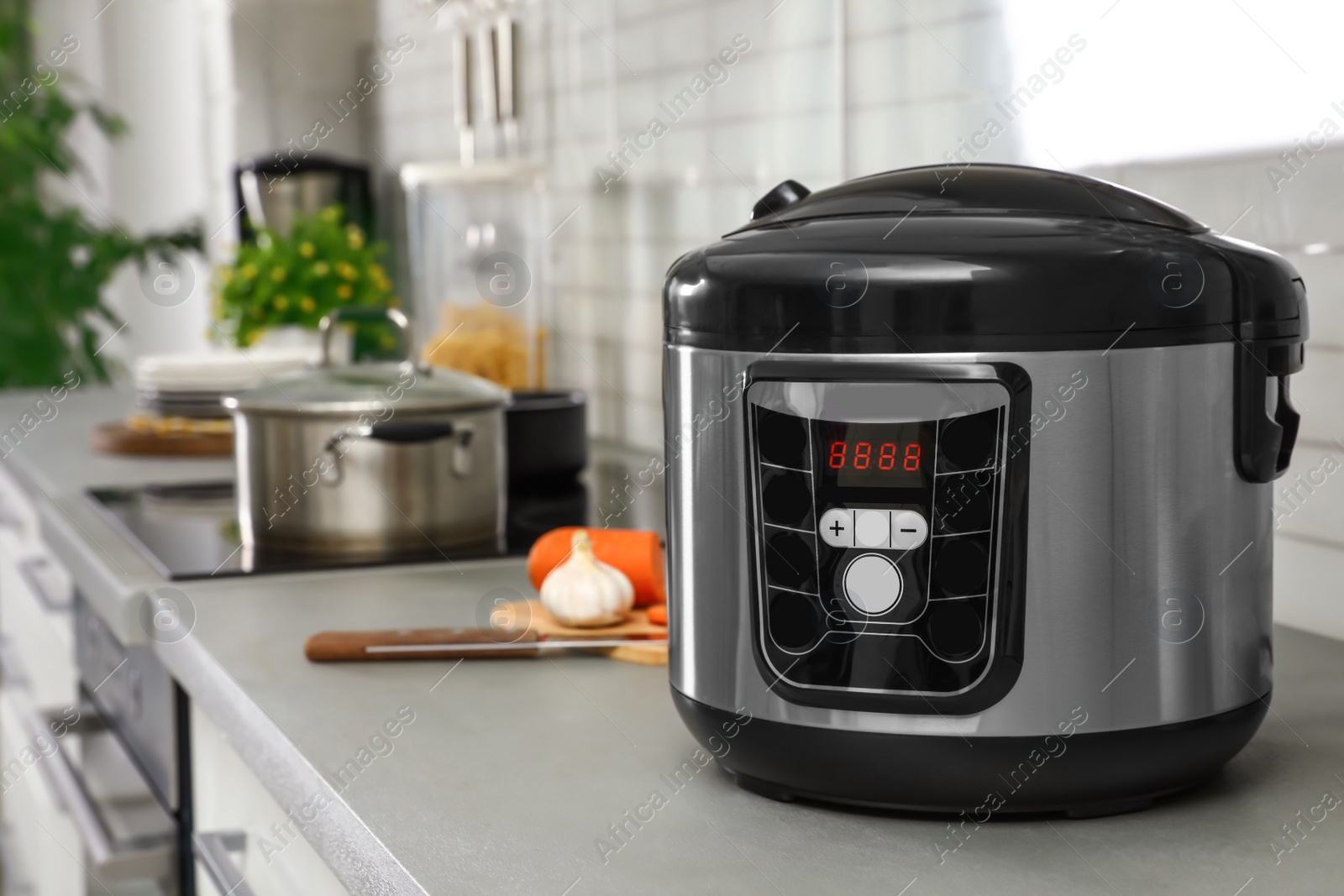 Photo of Modern multi cooker on table in kitchen. Space for text