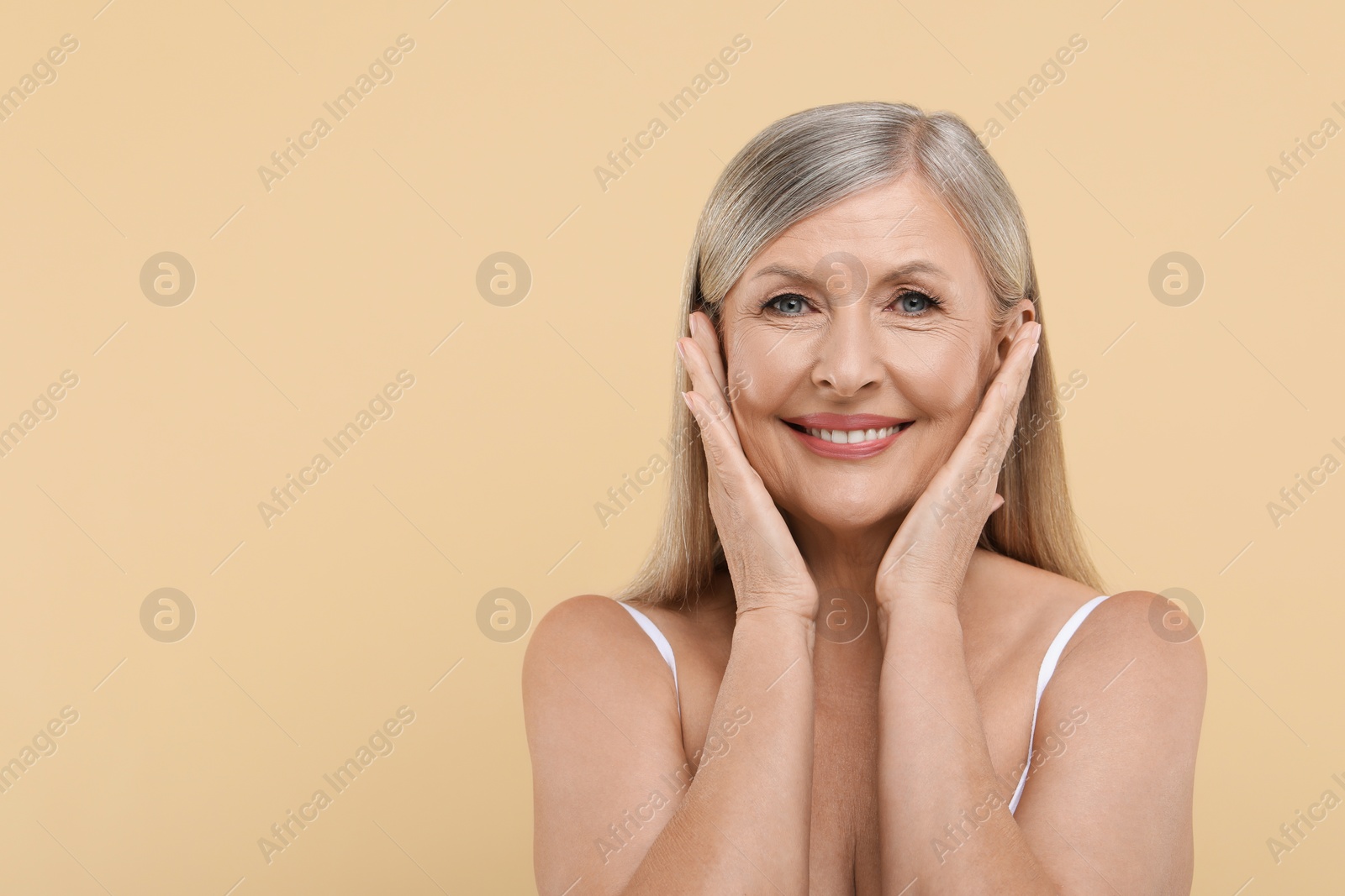 Photo of Portrait of beautiful senior woman on beige background. Space for text