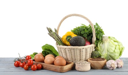 Photo of Healthy food. Basket with different fresh products on grey wooden table against white background