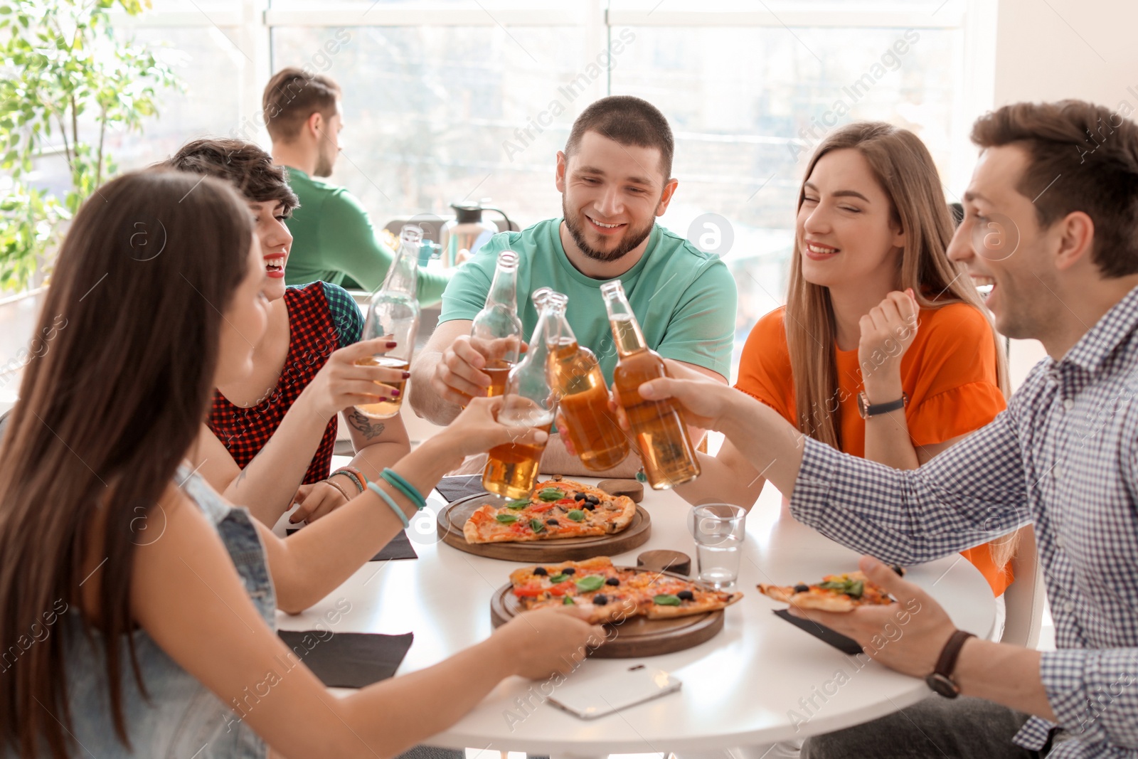 Photo of Young people having fun party with delicious pizza indoors