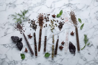 Flat lay composition with different spices and herbs on white marble table