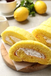 Photo of Delicious cake roll with cream filling on grey table, closeup