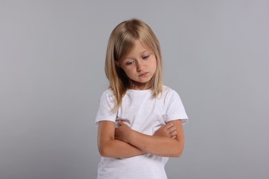 Photo of Resentful girl with crossed arms on grey background