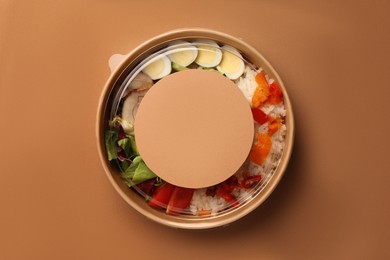 Tasty food in container on beige background, top view. Space for text