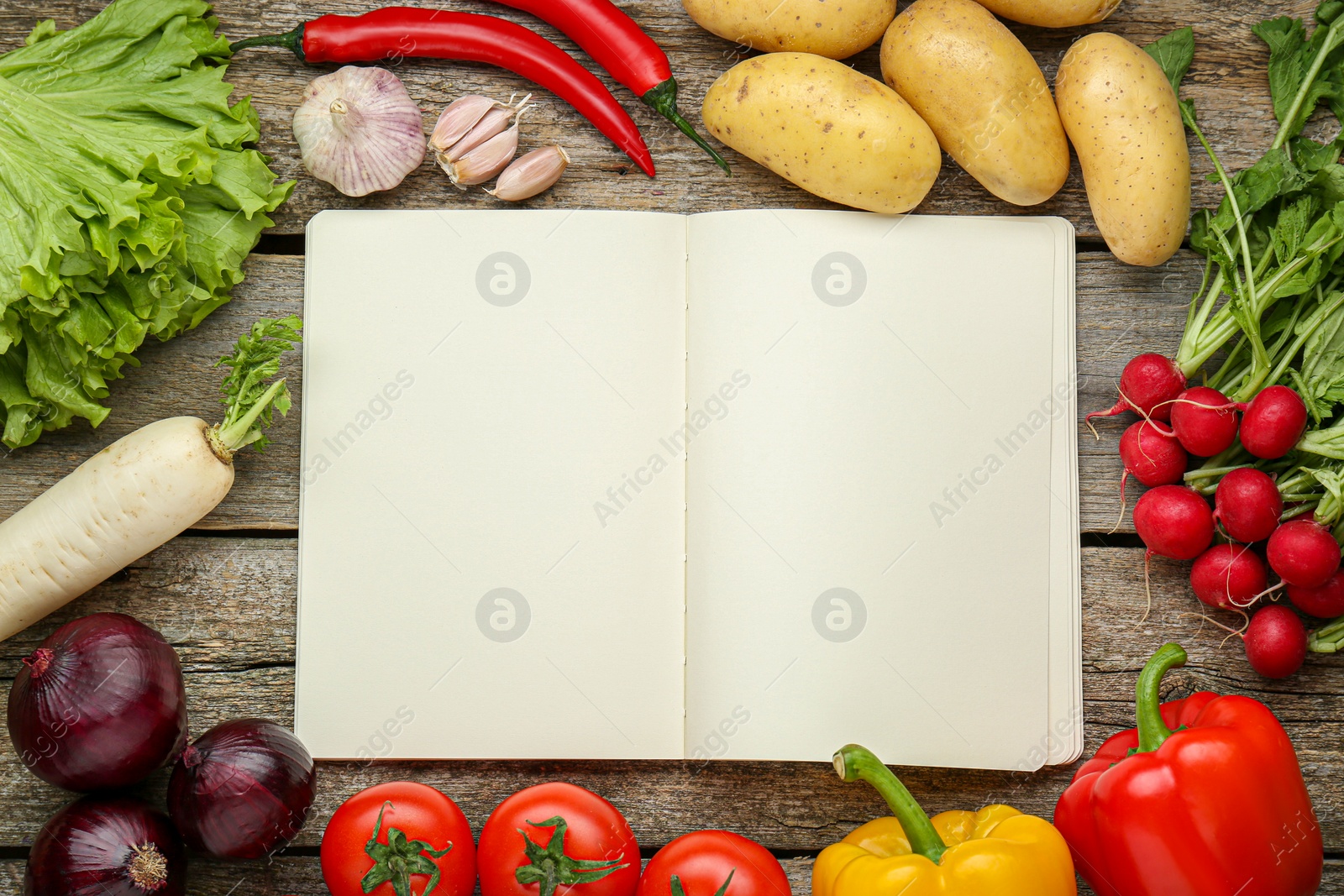 Photo of Blank recipe book and different ingredients on wooden table, flat lay. Space for text