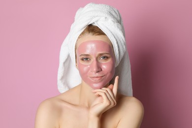 Photo of Young woman with pomegranate face mask on pink background