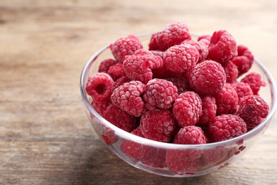 Photo of Tasty frozen raspberries on wooden table, closeup